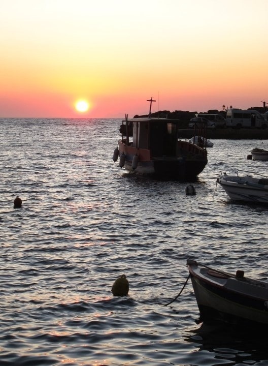 the santorini sunset, as seen from the bay of ammoudi in oia