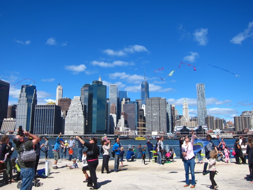 kite day in the park in dumbo, with a great view of downtown manhattan in the background