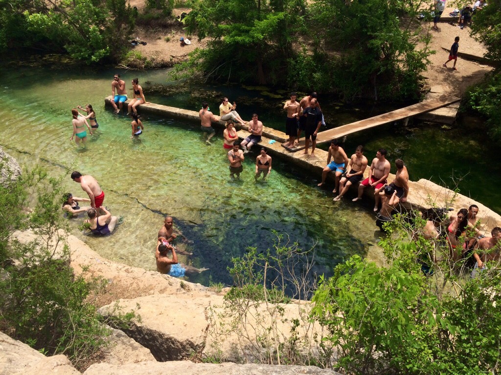 the scene at jacob's well in wimberley, texas (the dark circle in the water is the 30-foot well)