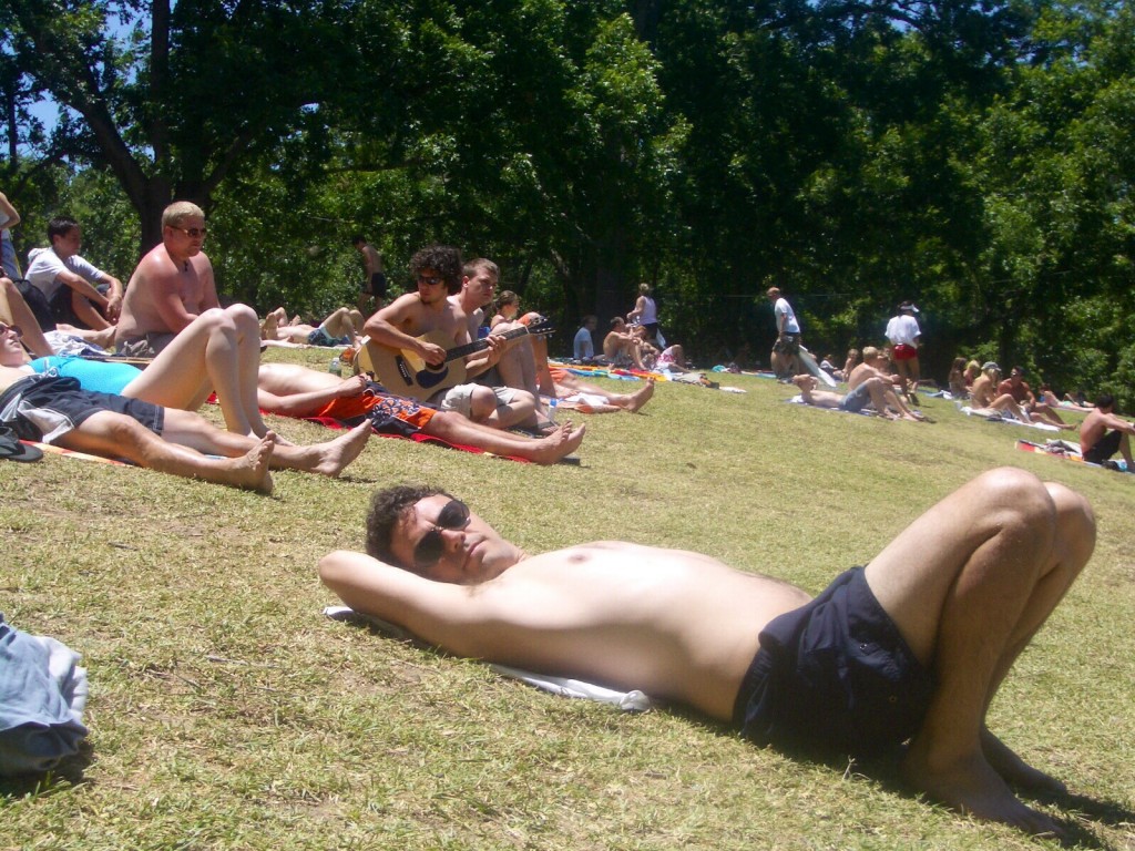 sun bathing at austin's barton springs, with a token guitar player in the background