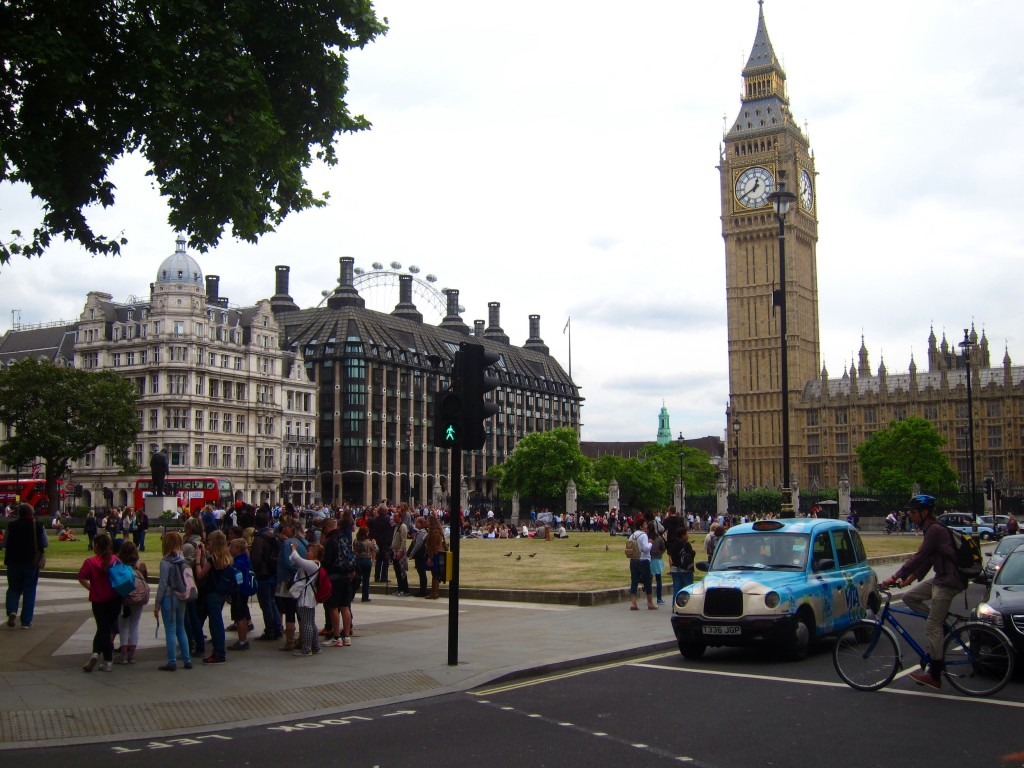 the scene in westminster: tourists, cabbies, big ben, and the london eye keeping watch in the background